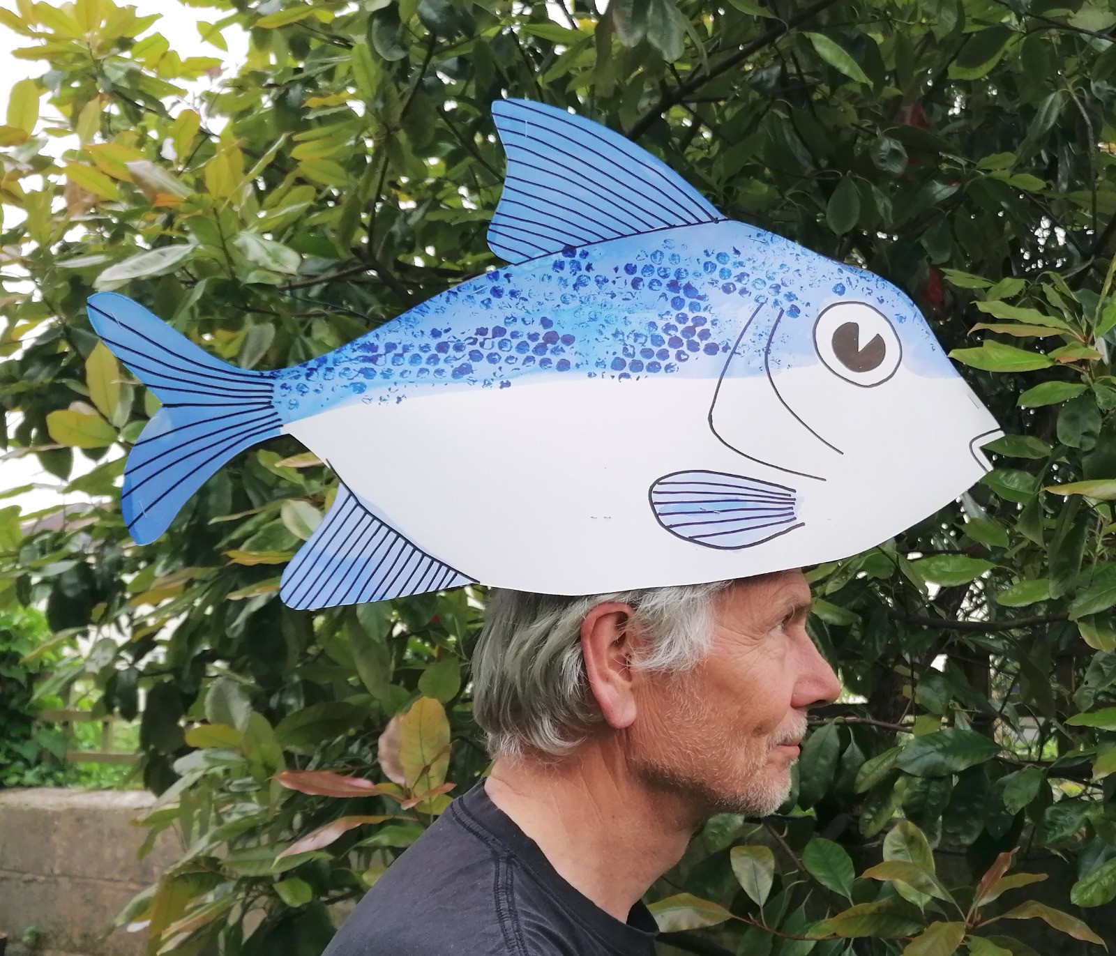 cardboard fish on a man's head