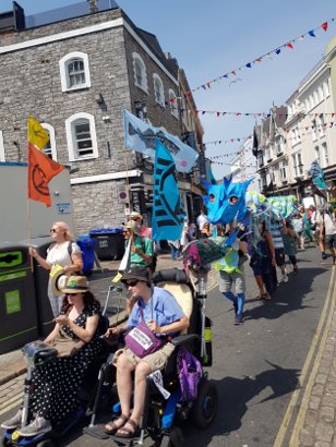 two people in wheelchairs at the front of a march