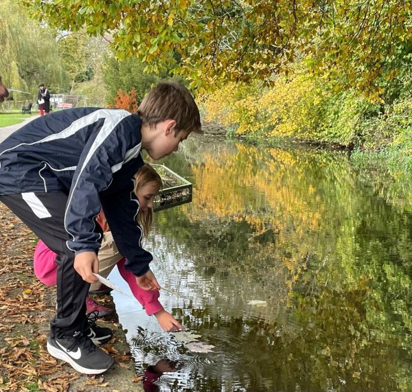 Children launching leaf boats