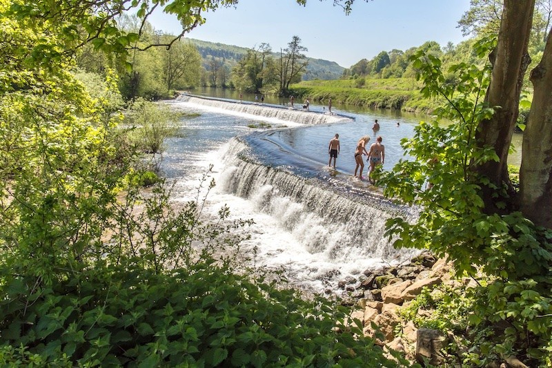 Photo: people at a small waterfall surrounded by nature
